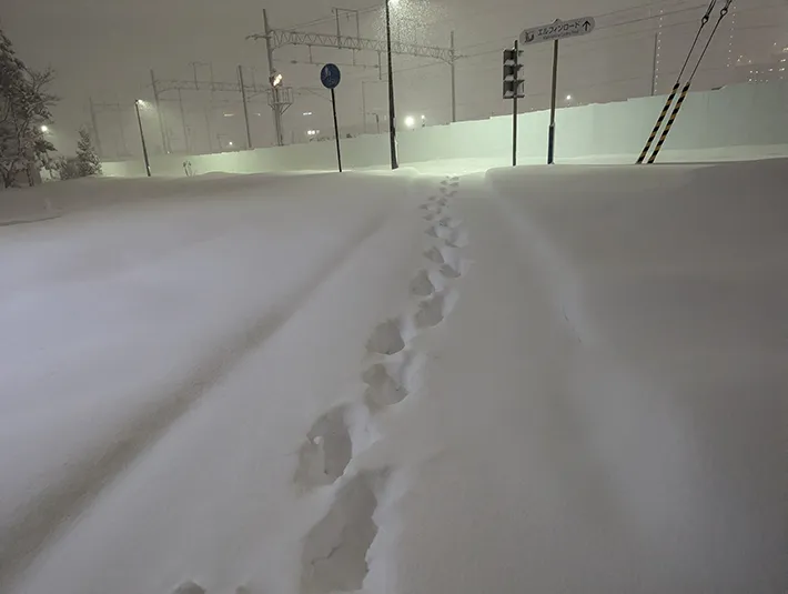 雪道に足跡がついている写真