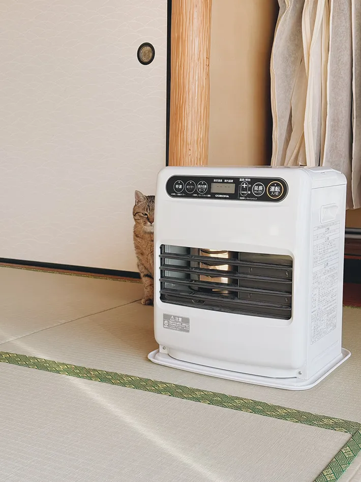 猫とファンヒーターの写真