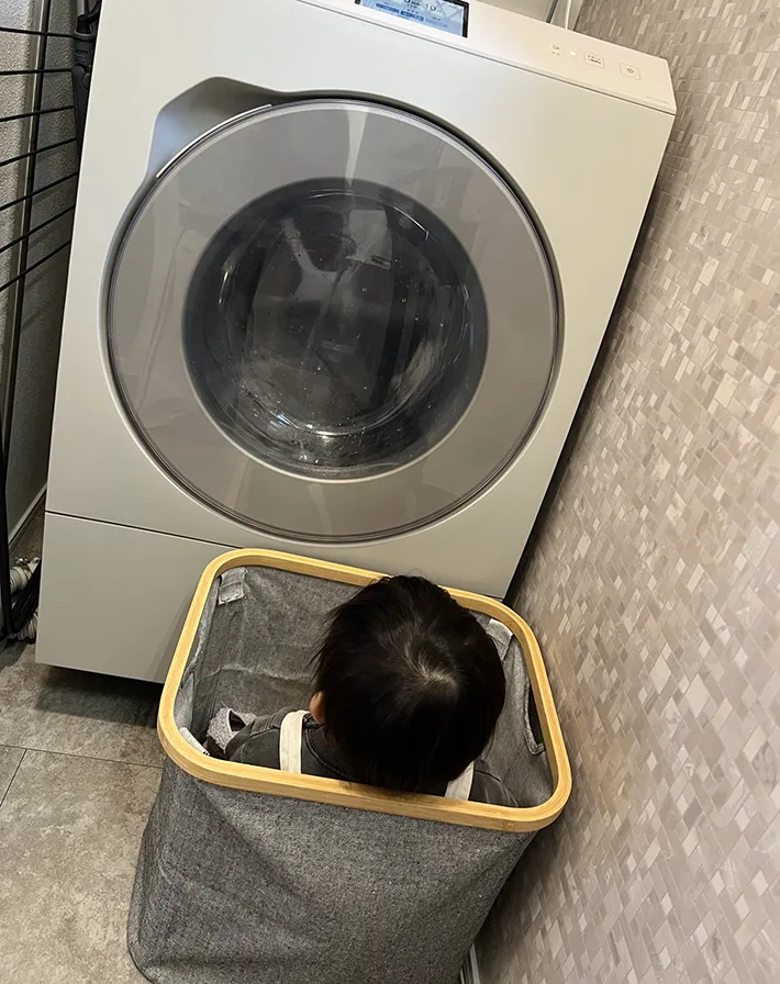 洗濯機を見る男の子の写真