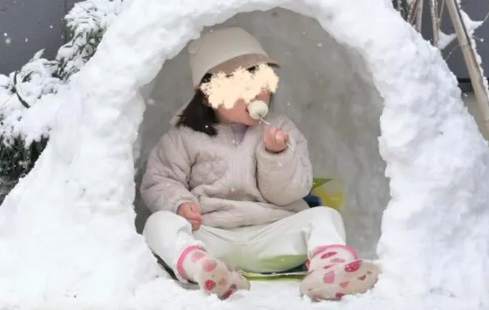 かまくらに入る女の子の写真