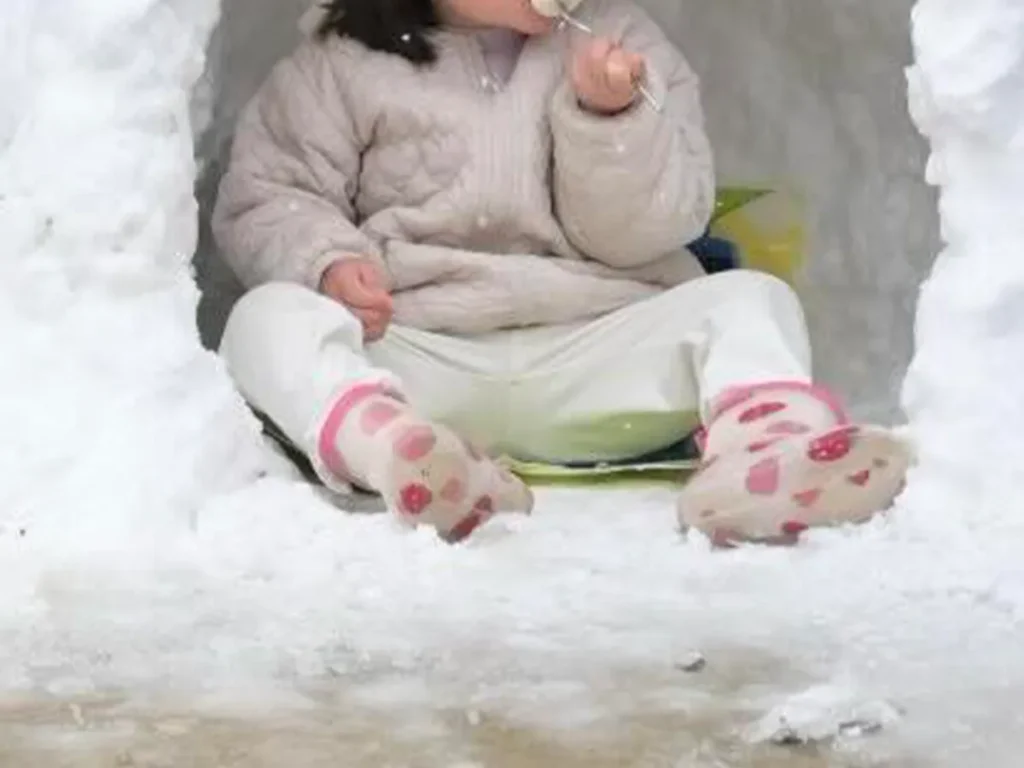 かまくらに入る女の子の写真