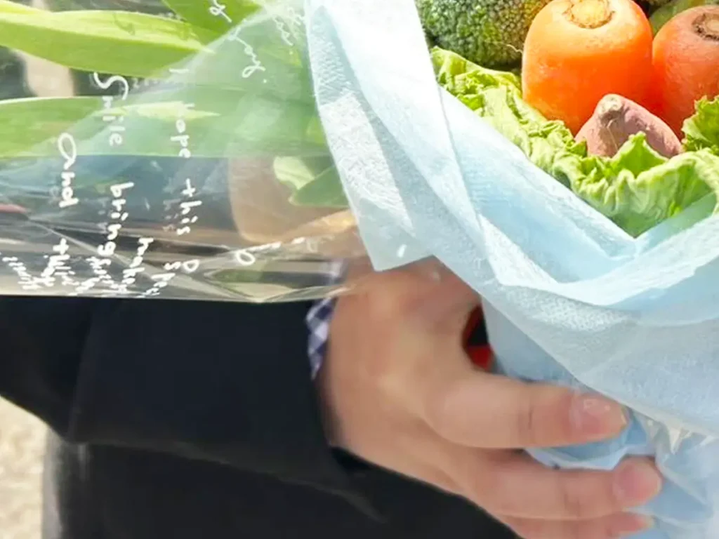 野菜のブーケを持つ高校生の写真