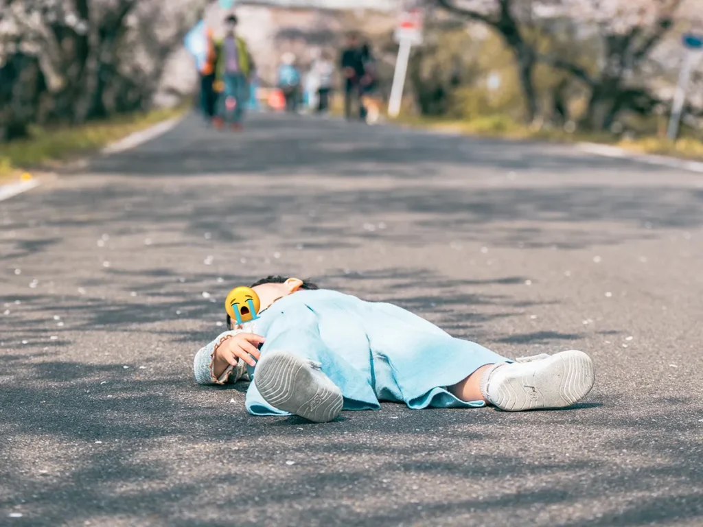 桜の木の下で寝転がる子供