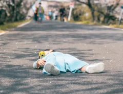 桜の木の下で寝転がる子供