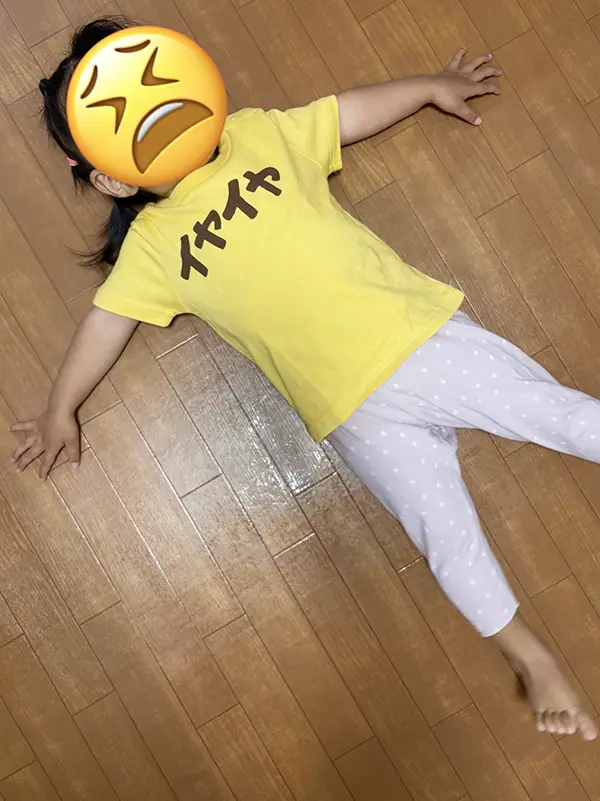 床に寝転ぶ2歳児の写真