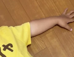 床に寝転ぶ2歳児の写真